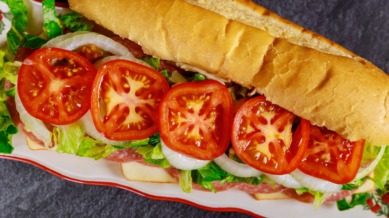 Open-faced sub sandwich lined with tomatoes