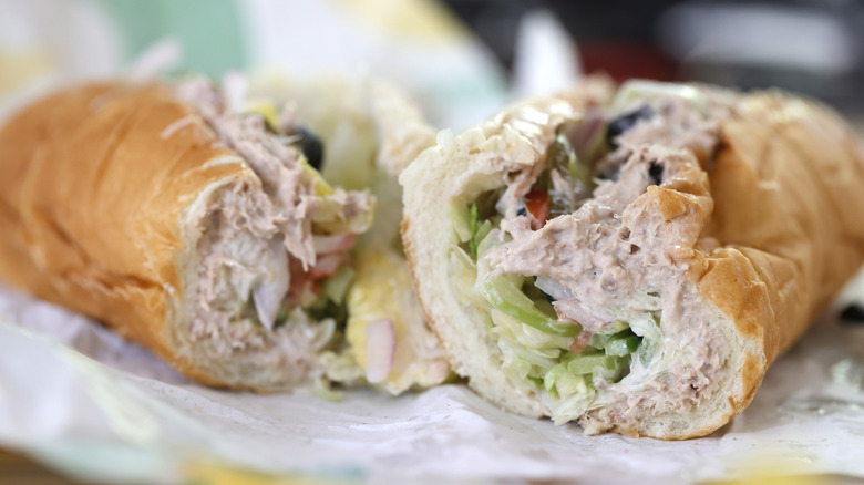 Subway's tuna sandwich sliced open on paper