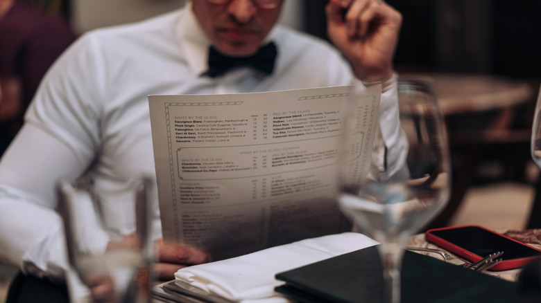 Man in bow tie looking at menu