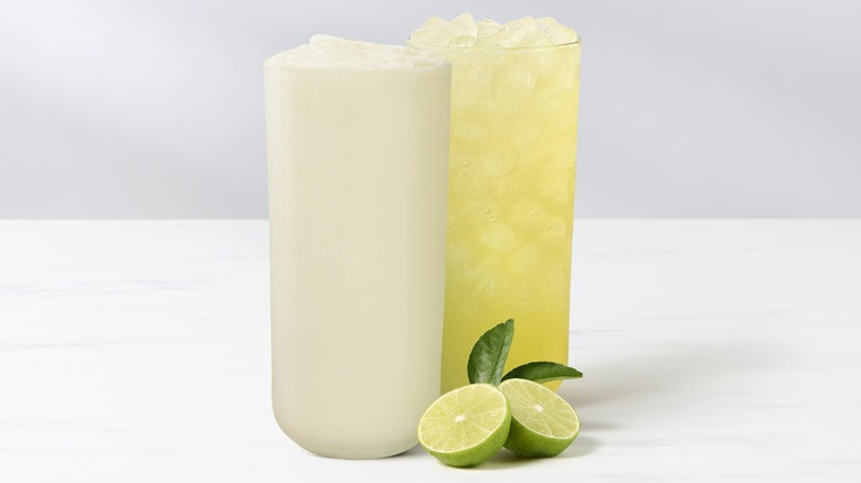 The Chick-fil-A Frosted Key Lime Lemonade beside the regular Chick-fil-A Key Lime Lemonade on a white surface.