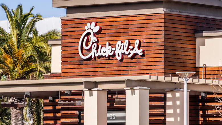 The exterior of a Chick-fil-A location with palm trees near it