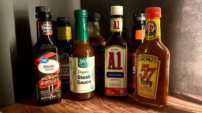 Various steak sauce bottles on wood table