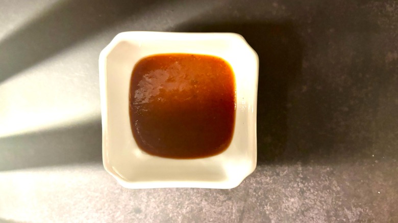 steak sauce in white ramekin on black surface