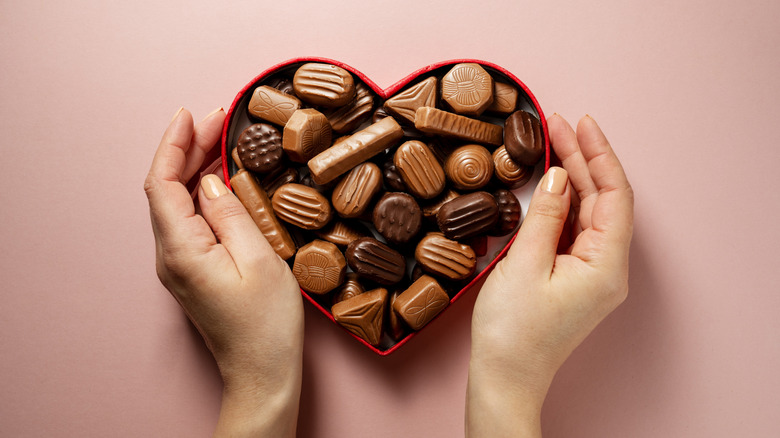 a box of Valentine's Day chocolates held by hands