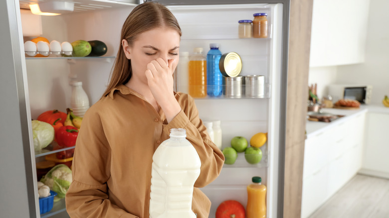 Person holding nose over spoiled milk