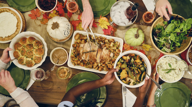 A group of people around a table filled with holiday foods.