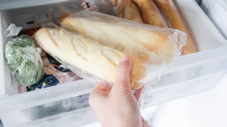 A person taking baguettes out of the freezer