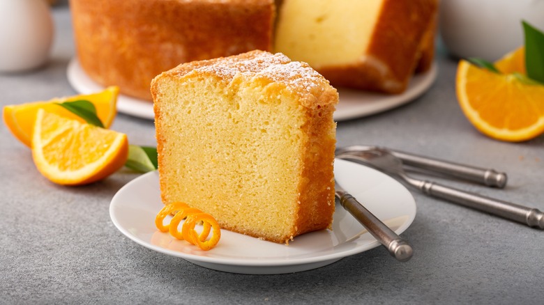 A slice of cake with orange zest in front of it