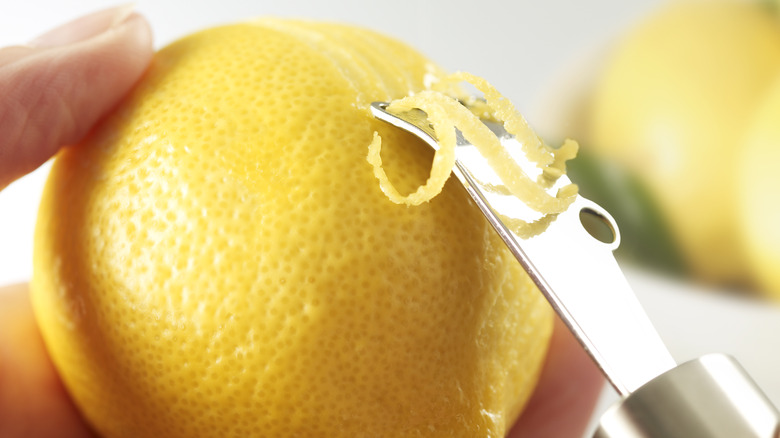 Person using a tool to get a bit of lemon zest