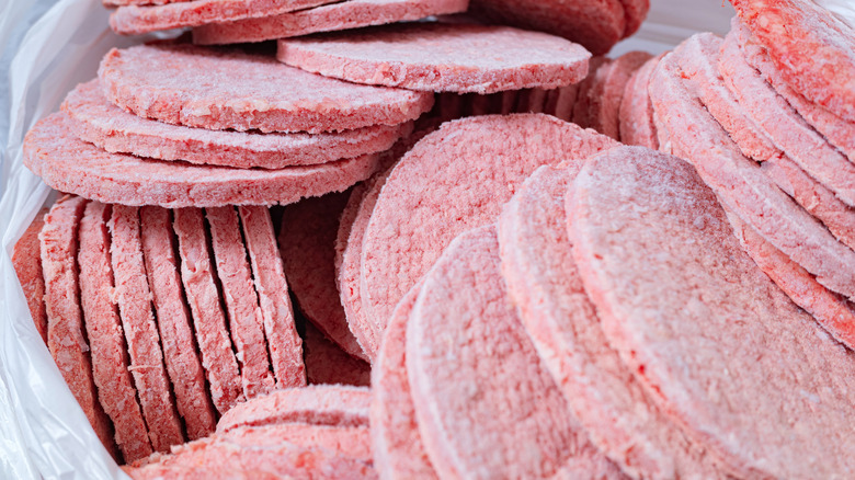 Frozen hamburger patties stacked together