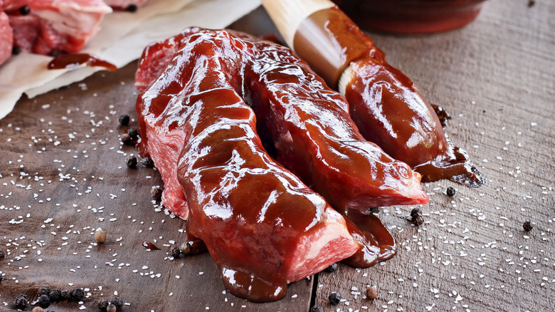 Brush putting sauce on country pork ribs