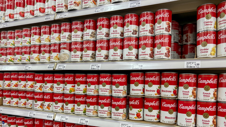 Rows of Campbell's soup cans on grocery store shelves.