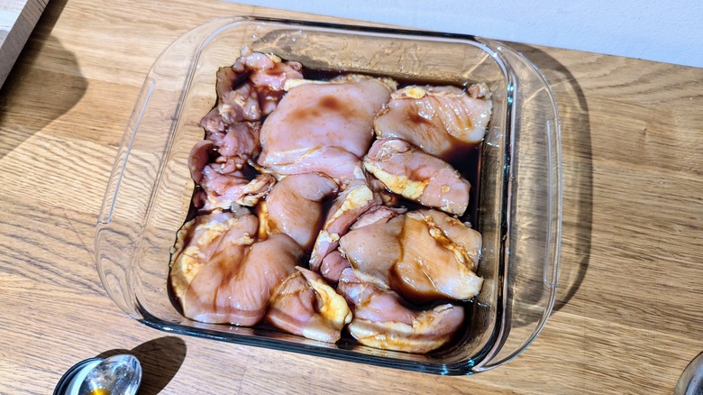 mr. yoshida's teriyaki sauce covering chicken in a baking pan