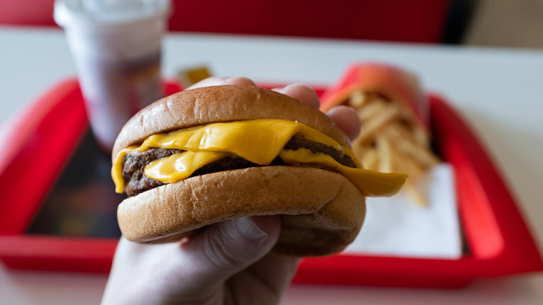 Close-up of hand holding fast-food burger