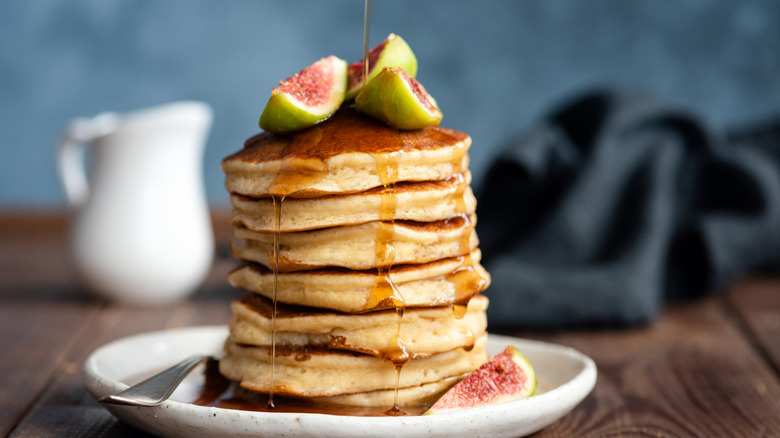 Stack of pancakes with maple syrup and figs