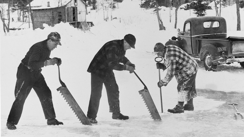 Men harvesting ice from a frozen river.