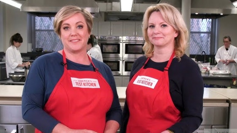 Hosts wearing America's Test Kitchen aprons