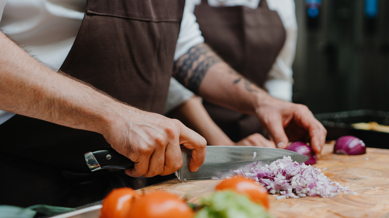 Close-up of chef chopping onions