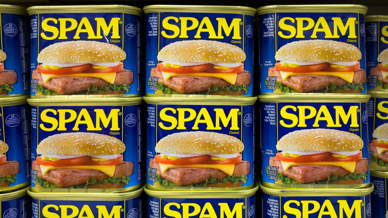 Cans of Spam lined up on a store shelf