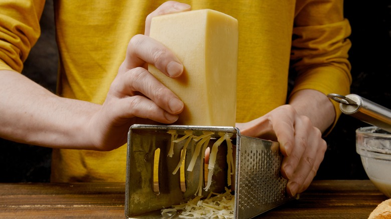 hand grating cheese on laid down box grater