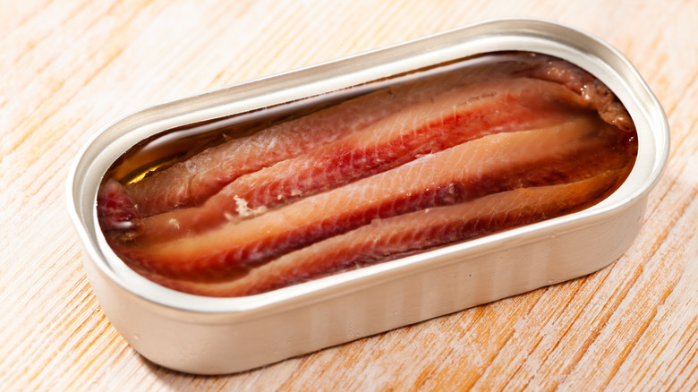 A tin of anchovies on a table.