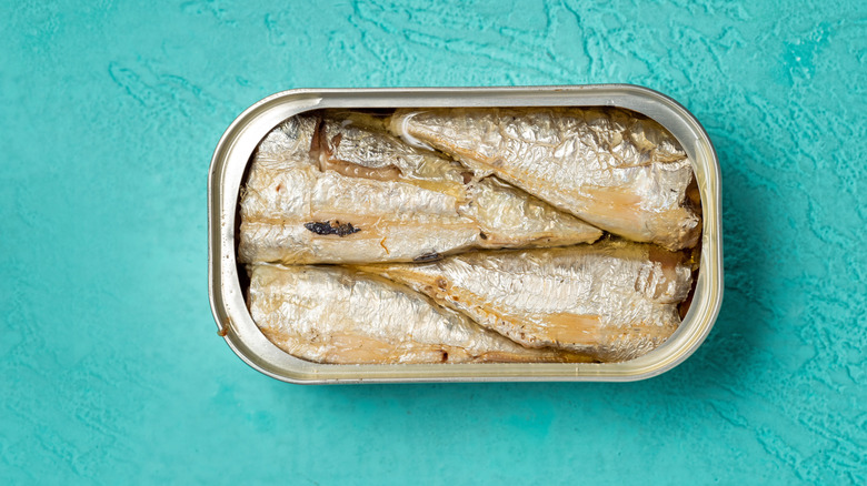 An open tin of sardines sitting on a counter.