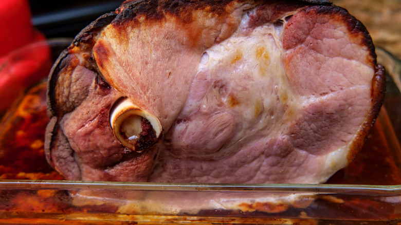 Bone-in ham, cooked, in a glass casserole dish