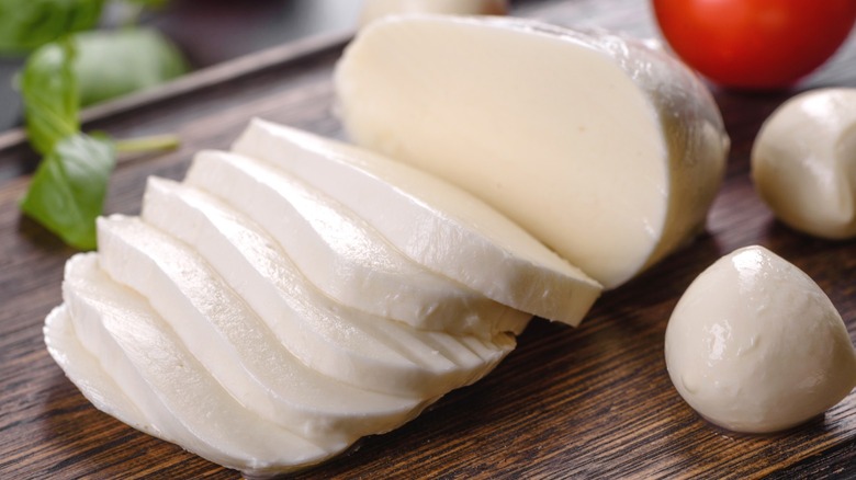 Sliced fresh mozzarella cheese on a cutting board