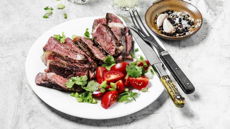 Steak and salad served on a plate.