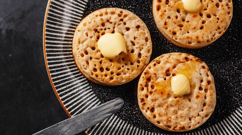 Buttered crumpets sitting on a plate.