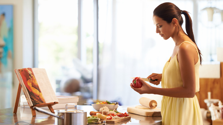 woman cooking from a recipe on a recipe stand