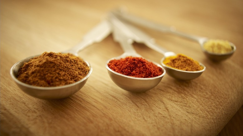 measuring spoons holding different spices inside them