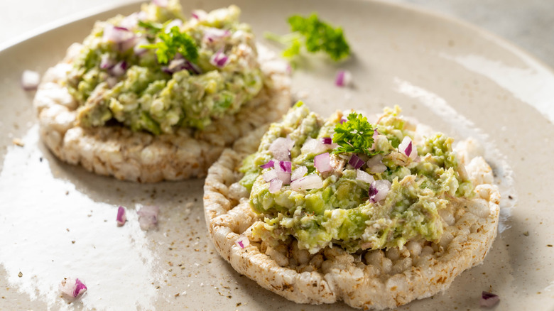 Tuna salad with mashed avocado on rice cakes