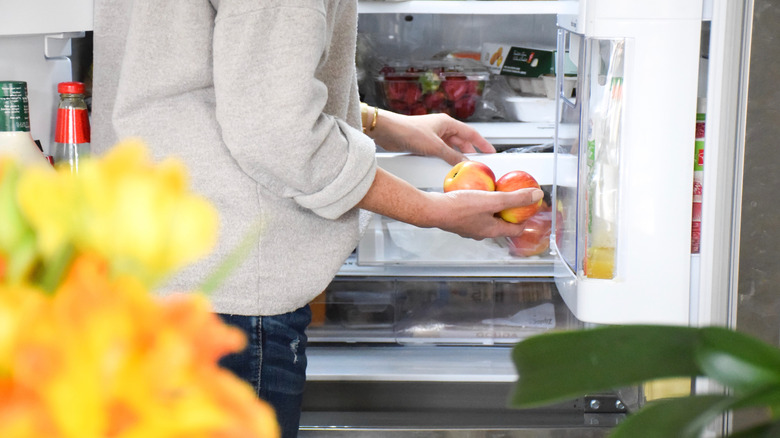 Woman using crisper drawer