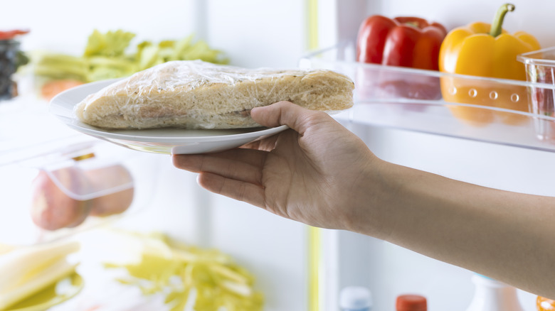 Hand with bread in fridge