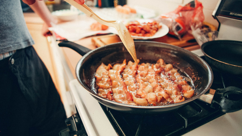 person frying bacon