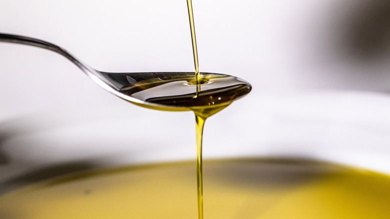 oil pouring over spoon