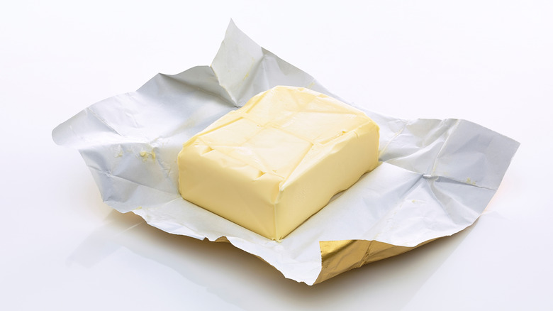 A block of butter with its wrapper opened