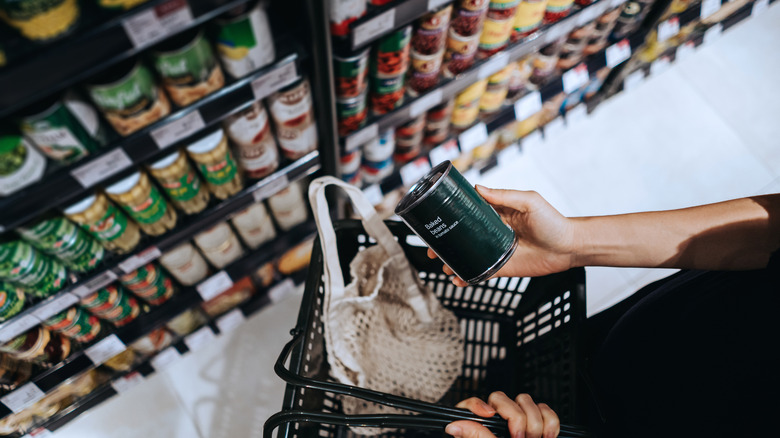 person shopping for canned goods