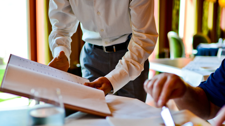 Waiter showing wine list