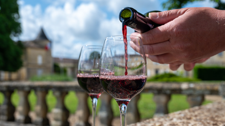 Person pouring two glasses of wine