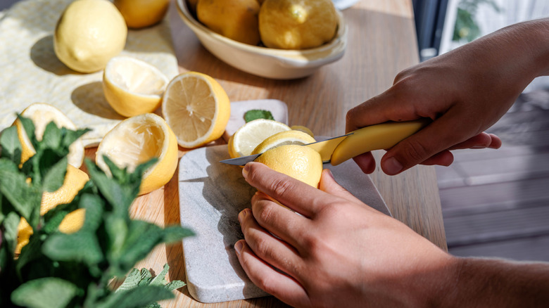 Hands cutting lemons