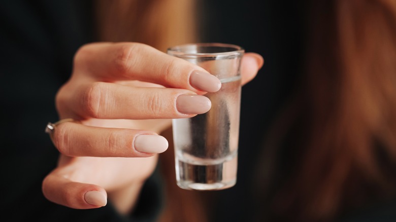 person reaching out with water glass