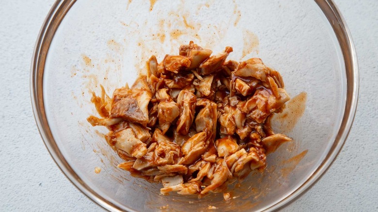 cooked chicken in a clear bowl with red sauce