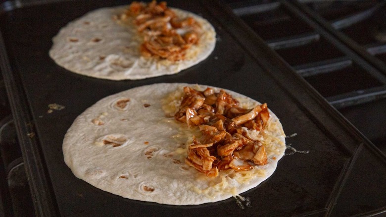 two flour tortillas with shredded cheese and chicken