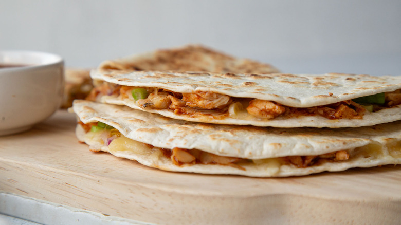 two quesadillas on a wooden board