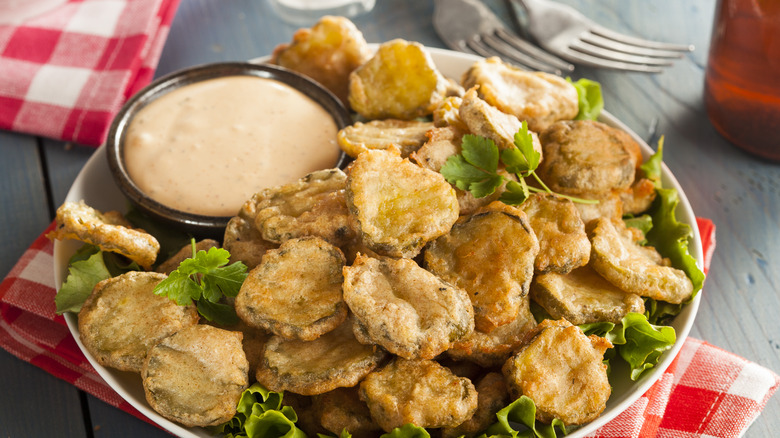 A bowl of fried pickles with a cilantro garnish