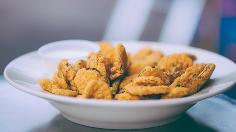 a bowl of fried pickles with dipping sauce