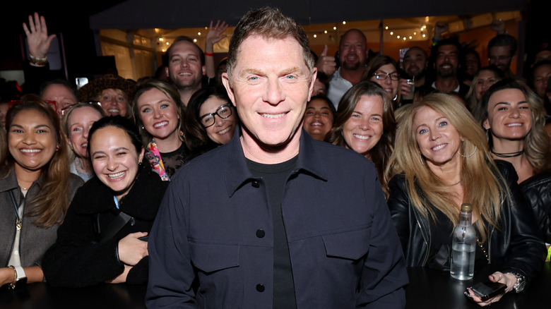 Bobby Flay smiling in front of a crowd of people