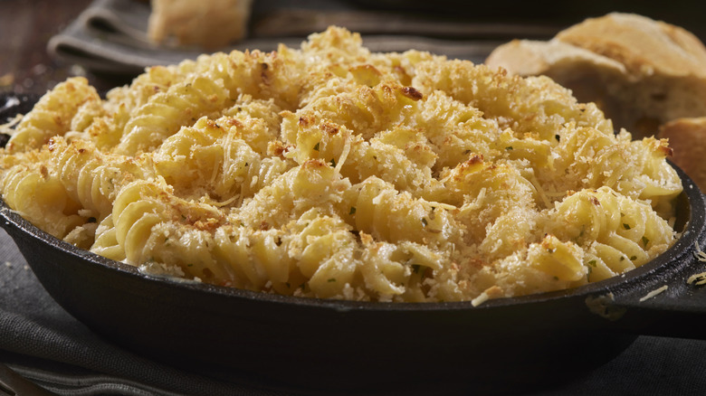 Macaroni and cheese with breadcrumbs on it in a black dish